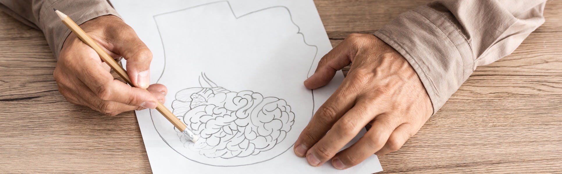 Person sketching picture of brain